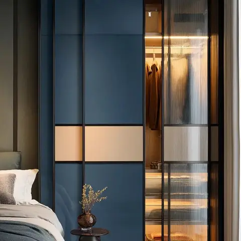 Bedroom corner with a navy-blue lacquer sliding wardrobe featuring a fluted-glass door that reveals an internally lit