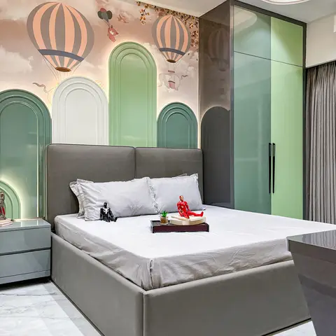 Kids' bedroom with a grey upholstered bed against a hot-air-balloon mural wall framed by green arched wall panels, and a