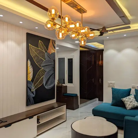 Living room with a vertical white panelled TV wall, oversized black-and-gold botanical artwork, a sculptural gold bubble