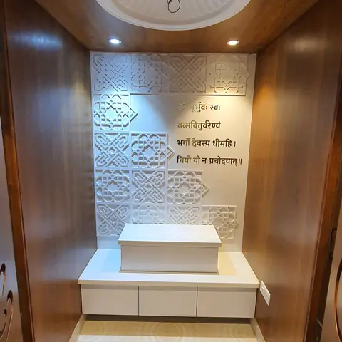 Dedicated pooja room with wood-panelled walls, a white carved jaali backwall inscribed with the Gayatri mantra, a marble