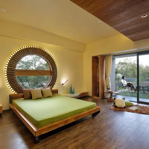 Bedroom with a backlit circular wood-slat window feature behind a low platform bed, wood-plank flooring and ceiling, opening