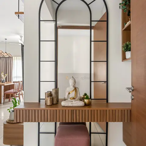 Entrance foyer with a tall arched black-framed mirror above a fluted wood console styled with a Buddha statue and wooden