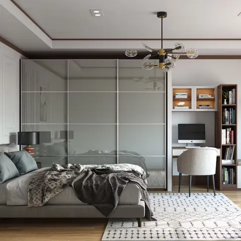 A bedroom with a smoked-mirror sliding wardrobe, a built-in study desk and bookshelf nook, and a cushioned window-seat