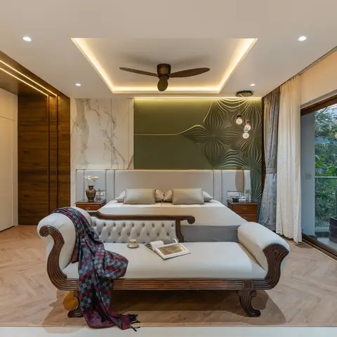 Master bedroom with a marble-and-textured olive accent wall behind the bed, a carved wood chaise lounge at the foot, and
