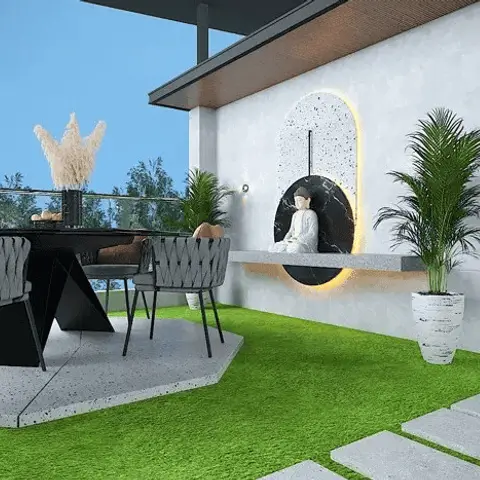 Outdoor terrace with a rope-weave dining set on artificial turf, facing a backlit arched niche wall holding a Buddha statue