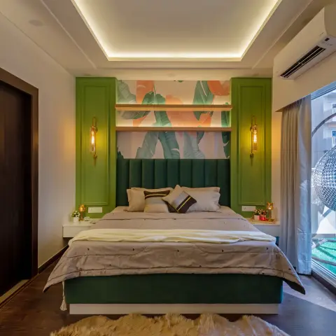Bedroom with a channel-tufted bottle-green velvet headboard running wall to wall, banana-leaf mural wallpaper above it lit