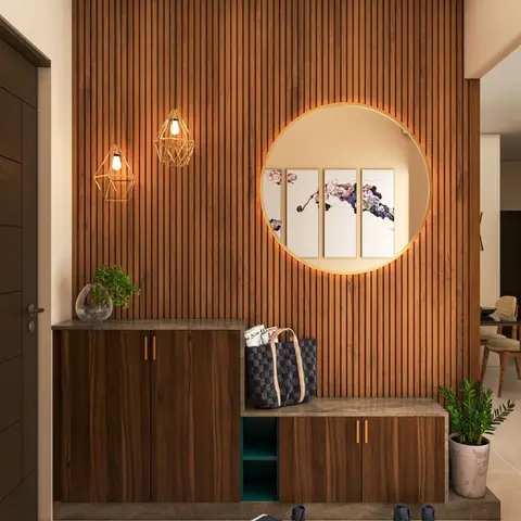 An entryway with a fluted wood-slat feature wall centred on a backlit circular niche framing three botanical art panels,