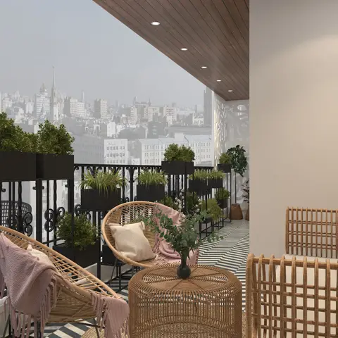 Boho-styled balcony with round rattan chairs, a woven rattan drum table, a row of black planters along the railing, and a