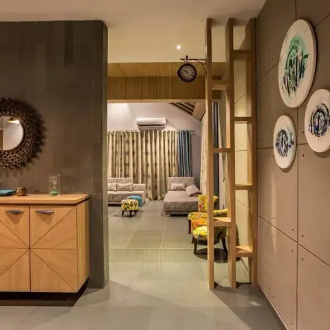 Entrance foyer with a sunburst mirror over a herringbone-front wood console, next to a textured concrete wall styled with