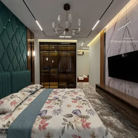 Bedroom with a teal diamond-tufted upholstered headboard wall, a sputnik chandelier, a marble slab TV feature wall, and a