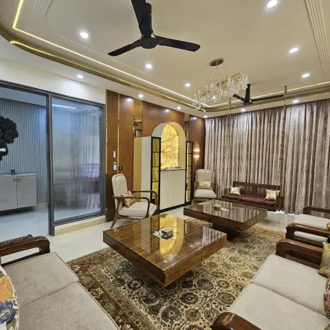 Opulent living room with a crystal chandelier over a carved wood sofa set on a Persian-style rug, a wall-mounted Buddha art