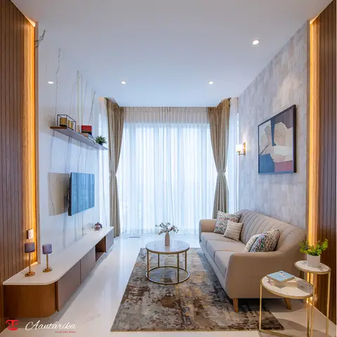 A narrow living room framed by backlit fluted wood side panels, with a channel-tufted beige sofa, a round marble-and-brass