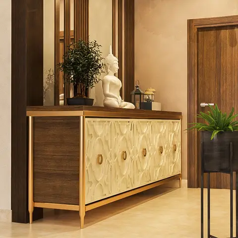Entryway console in dark wood with gold trim and carved fretwork door panels, styled with a Buddha statue, a bonsai plant,