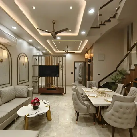 Open-plan living and dining space with a layered cove-lit POP ceiling, a metal jaali TV divider, a marble dining table with