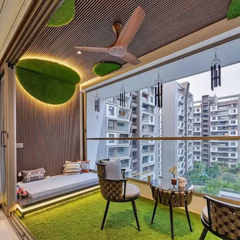Balcony sit-out with artificial-turf flooring, a wood-slat cove-lit ceiling with moss accents, a built-in daybed bench, and