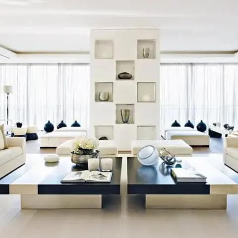 Symmetrical living room with two cream sofas facing each other across matching dark coffee tables, floor-to-ceiling
