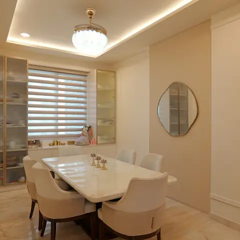 Formal dining room with a marble-top table and cream upholstered chairs beneath a crystal ceiling light, flanked by